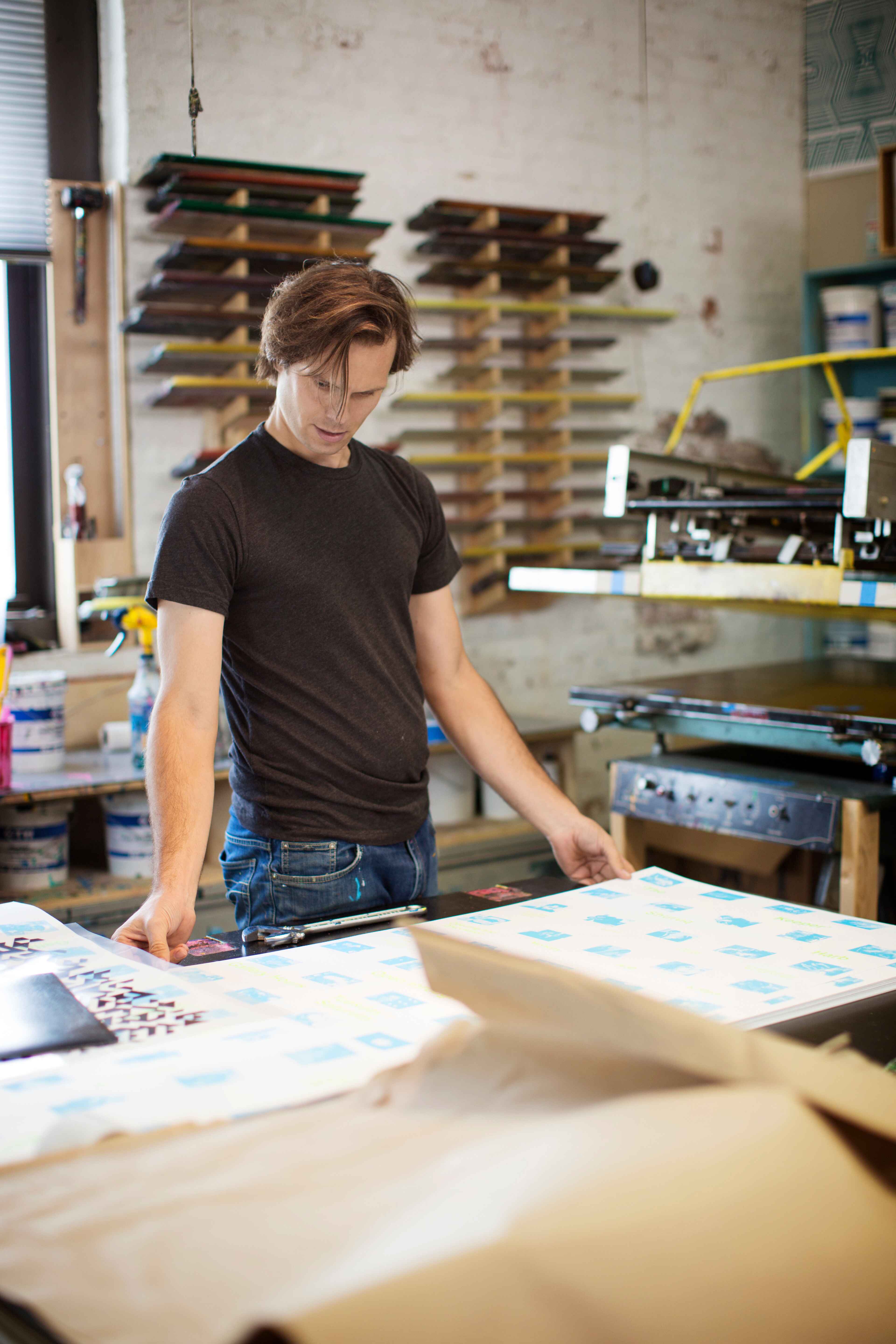 A man looking at printed graphic paper 