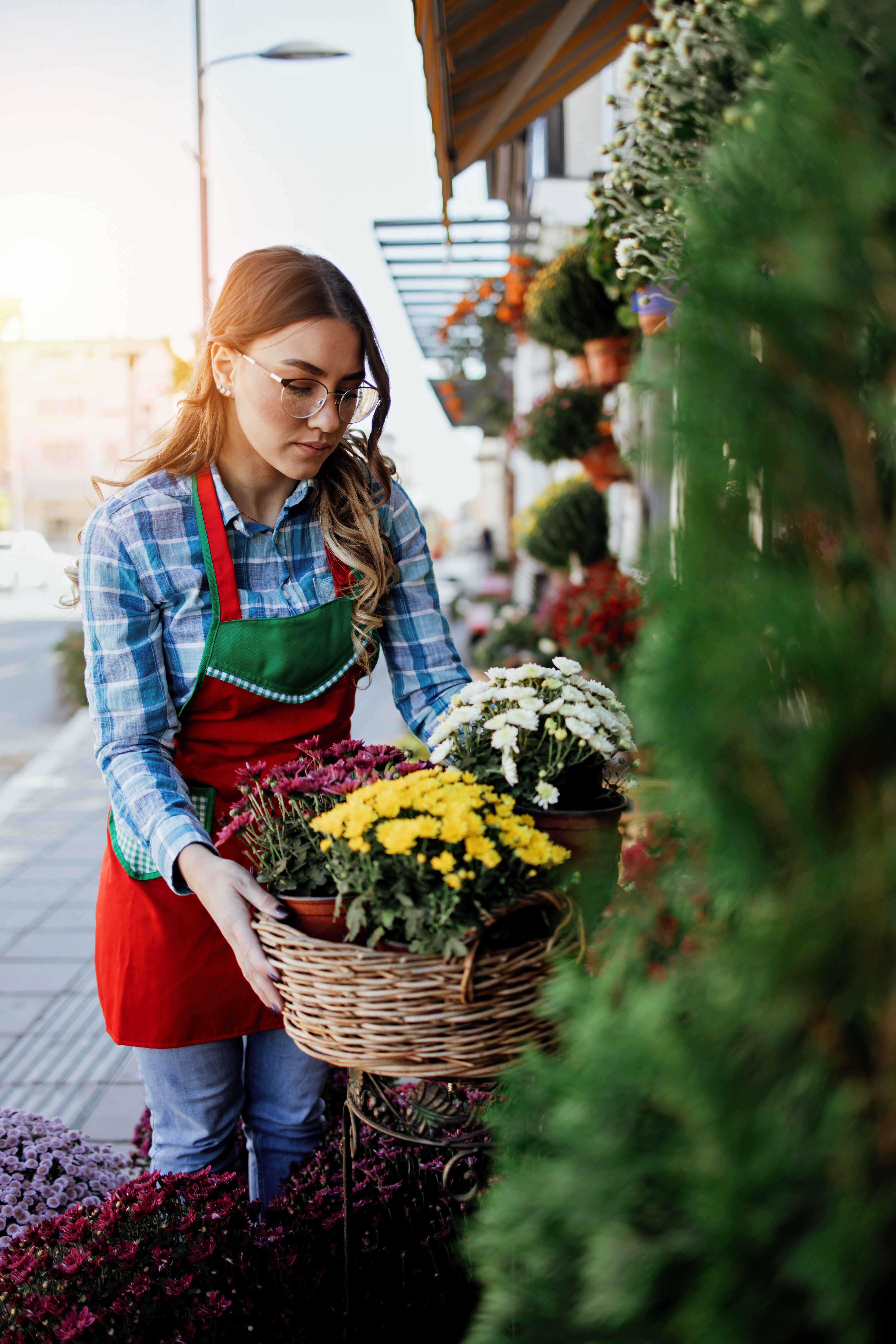 a business owner putting setting out flowers