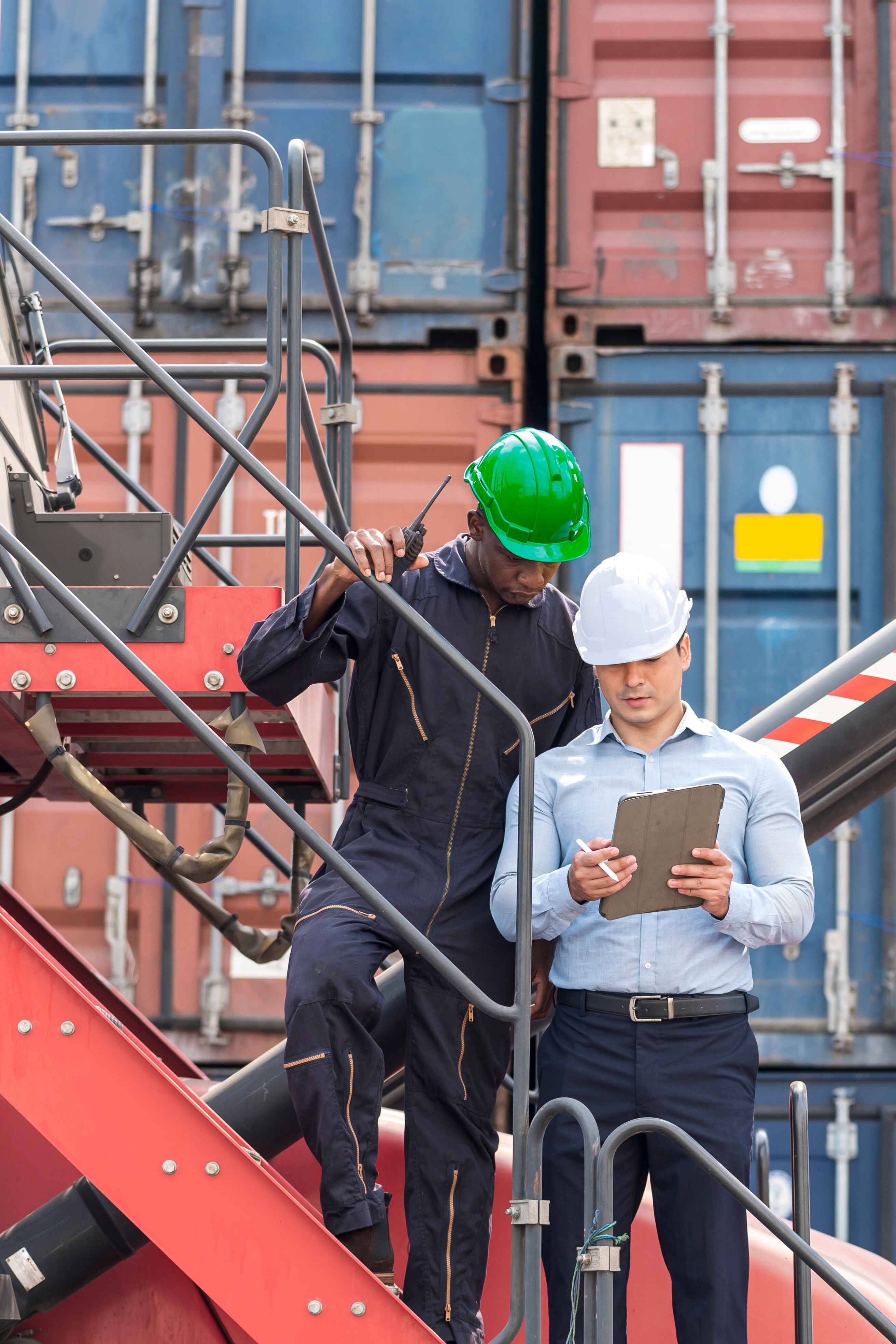 two men looking at a report with hardhats on. 