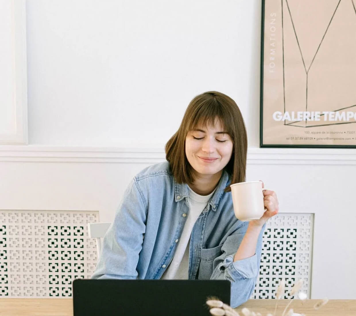 A woman drinking coffee with a content look on her face